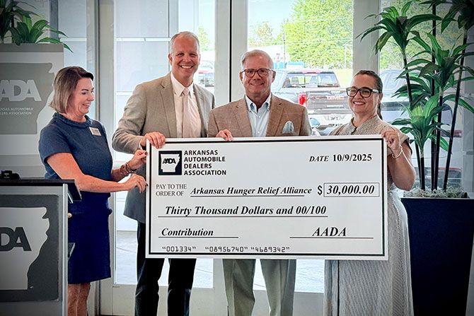 Teaming Up To Fight Hunger; Four people smiling while holding a large check for $30,000 from the Arkansas Automobile Dealers Association, addressed to the Arkansas Hunger Relief Alliance.