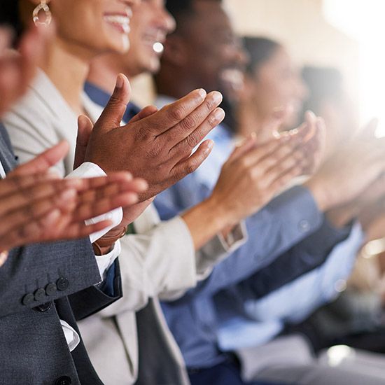 Group of smiling people clapping